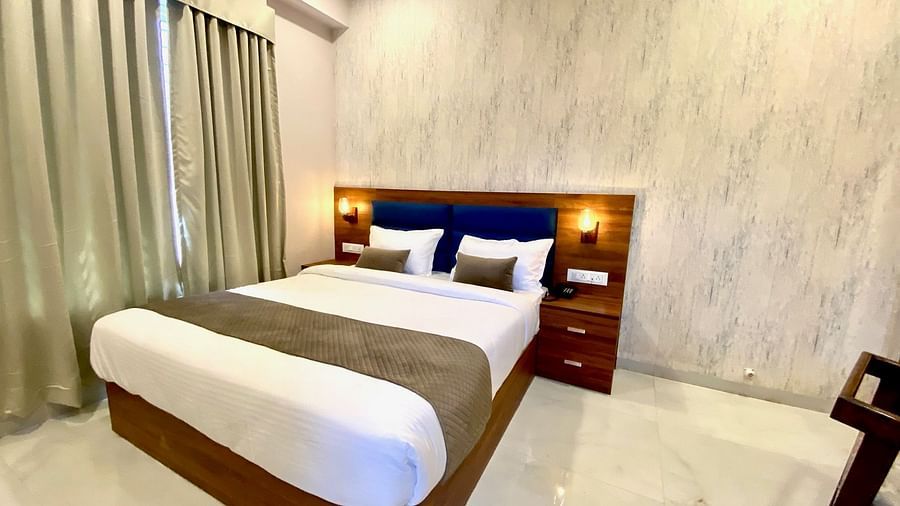 Room with comfortable double bed and wooden headboard  at Hotel Mumbai House, Indore