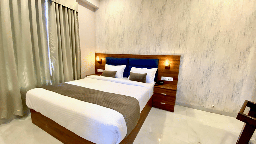 Room with comfortable double bed and wooden headboard  at Hotel Mumbai House, Indore