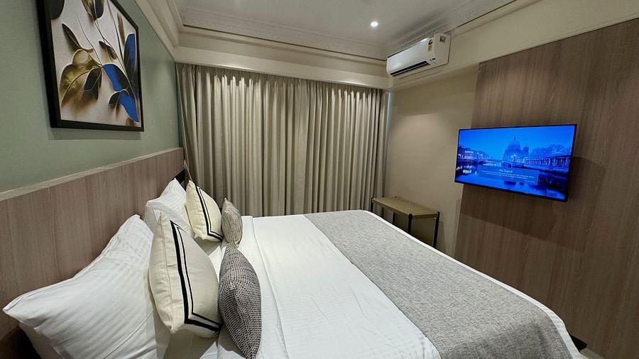 A king bed, a paiting hung above the bed and a tv wall mounted opposite the bed inside superior room - Hotel Mumbai House, Valnai, Malad