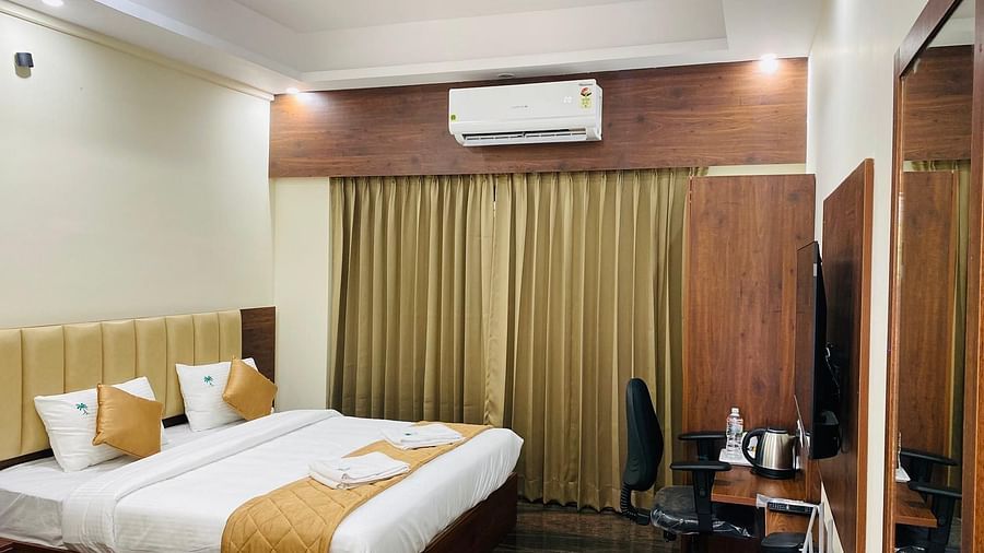 Elegant room featuring large bed, full-length curtains, and cosy ambience at Hotel Sahara Tree.