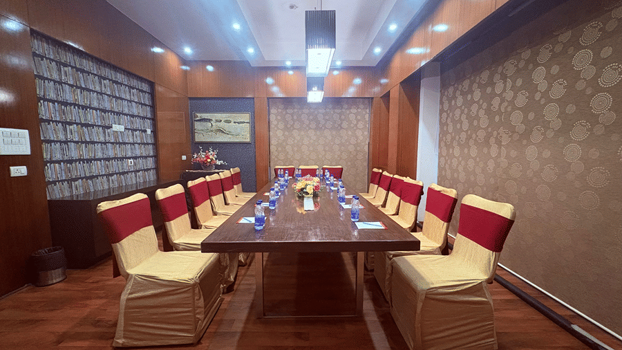 Front view of the Alpha Boardroom featuring a long wooden conference table lined with chairs around it at The Senses Hotel.
