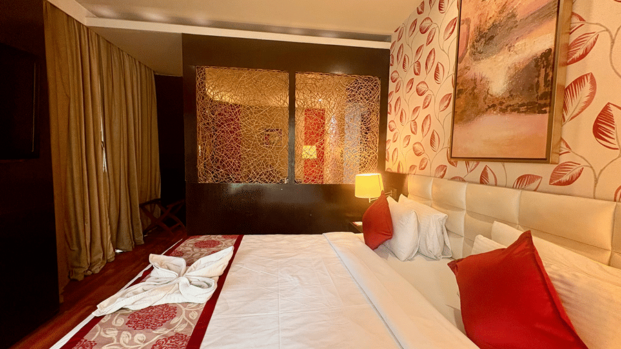 Side view of the bedroom at Executive Suite with King-size bed at Senses Hotel with a partition to separate the living area and a window with closed curtains.