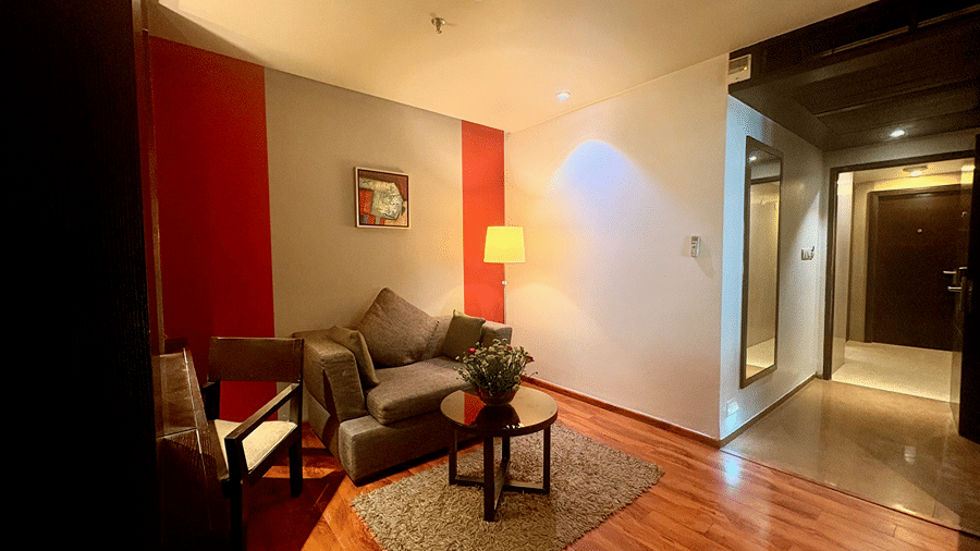 Sitting area in the Executive Suite at Senses Hotel with the lit, mirrored entryway and door opening which leads to the hotel corridor.