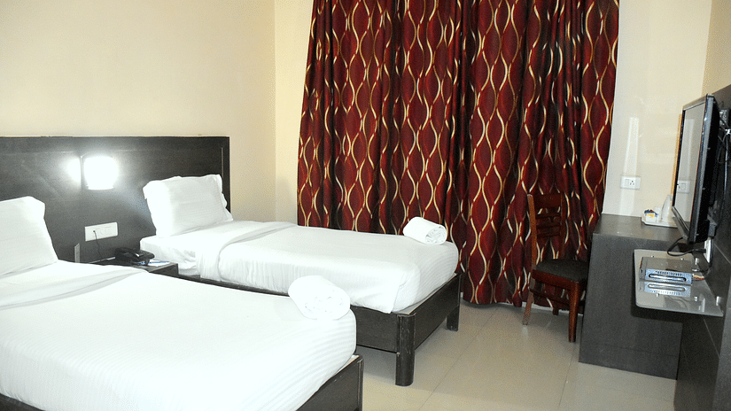 A sideview of twin beds in Deluxe Rooom | Hotel City Inn, Varanasi