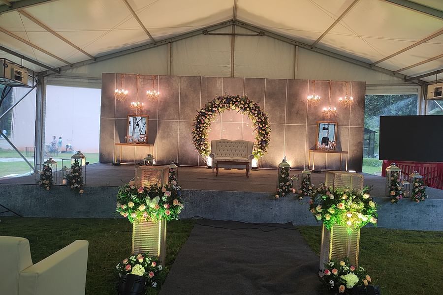 An event tent, focusing on the stage area with floral decorations, ready for a celebration or wedding - Black Thunder, Coimbatore