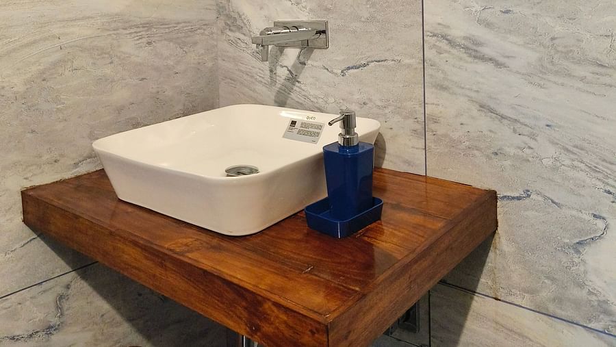 A sink and a mirror in the washroom at 103 room at Ananda Holiday Home, Wayanad 6