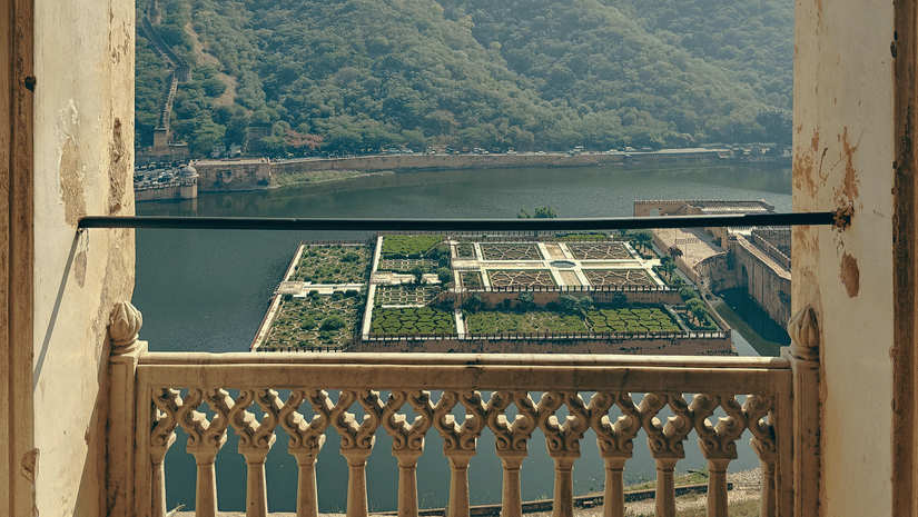 Balcony shot at the Amer Fort, overlooking Maota Lake and a geometric garden.