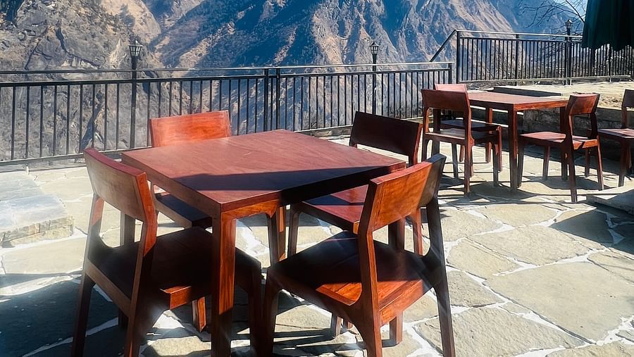 Image of a dining space in a balcony with views of the mountains in the background | Faraway Cottages, Auli
