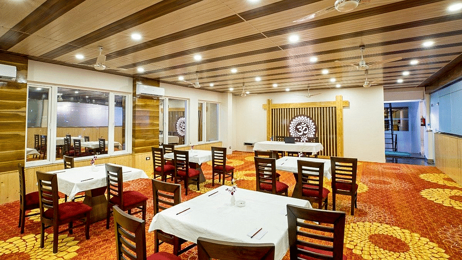 Full view shot of the Banquet Hall taken from behind featuring an Om symbol at the far end of the hall at Regenta Inn DLS.