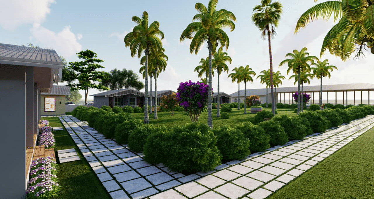A garden area featuring a white walkway lined by low green hedges and several palm trees at Trishvam Palolem Beach Resort, Goa.