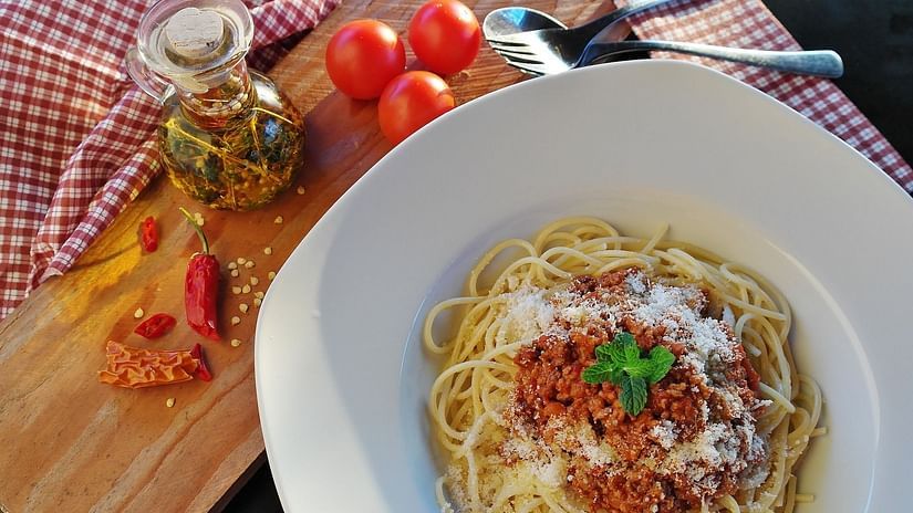 Spaghetti noodles garnished with sauce and mint leaves