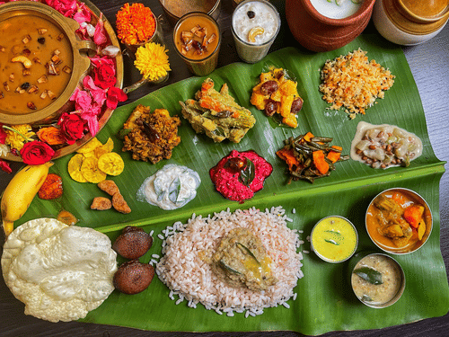Traditional Kerala sadya served on a banana leaf with rice, curries, pickles, papadum, and festive vegetarian accompaniments arranged