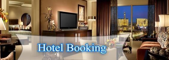 A room interior with a bed, sofa, chairs, table and TV showing a hotel booking sign.