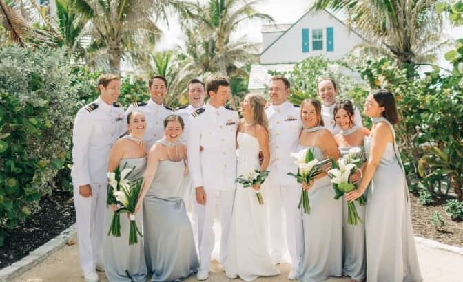 Group poses for a wedding photo among palm trees at Abaco Inn, bride and groom at the center.