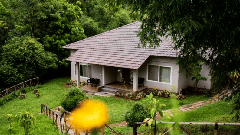 A picturesque cottage surrounded by vibrant greenery, ideal for a tranquil escape into nature at Abad Brookside Lakkidi, Wayanad, one of the best Resorts near Nagarhole Tiger Reserve.