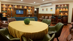 A hotel lounge or restaurant area with a large round table and a couch.