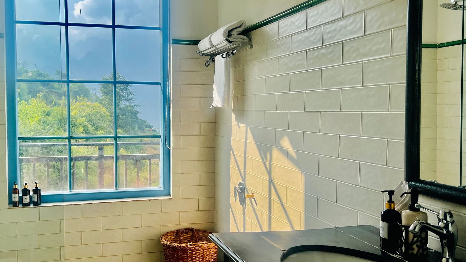 Modern hotel bathroom with large windows overlooking lush greenery, featuring a freestanding tub and minimalist decor | Faraway Cottages, Auli