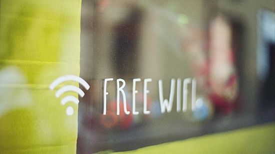 Free Wi-fi sign displayed on a window with a yellow reflection