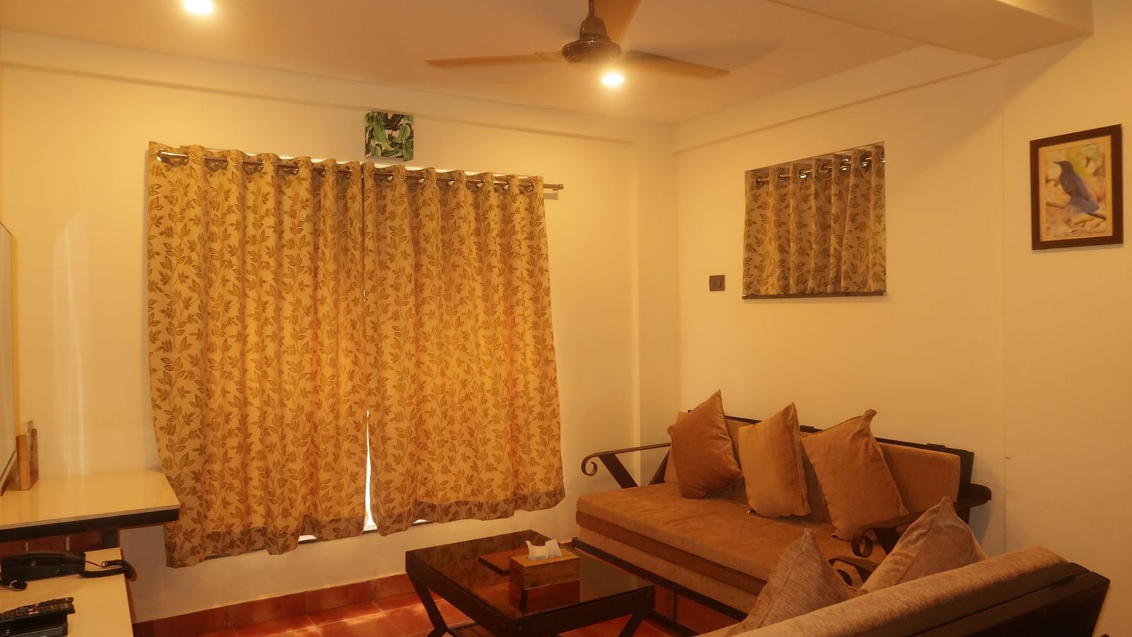 Guests can relax in the cozy living room at Forest Escape, featuring a sofa, coffee table, curtains, and a ceiling fan.