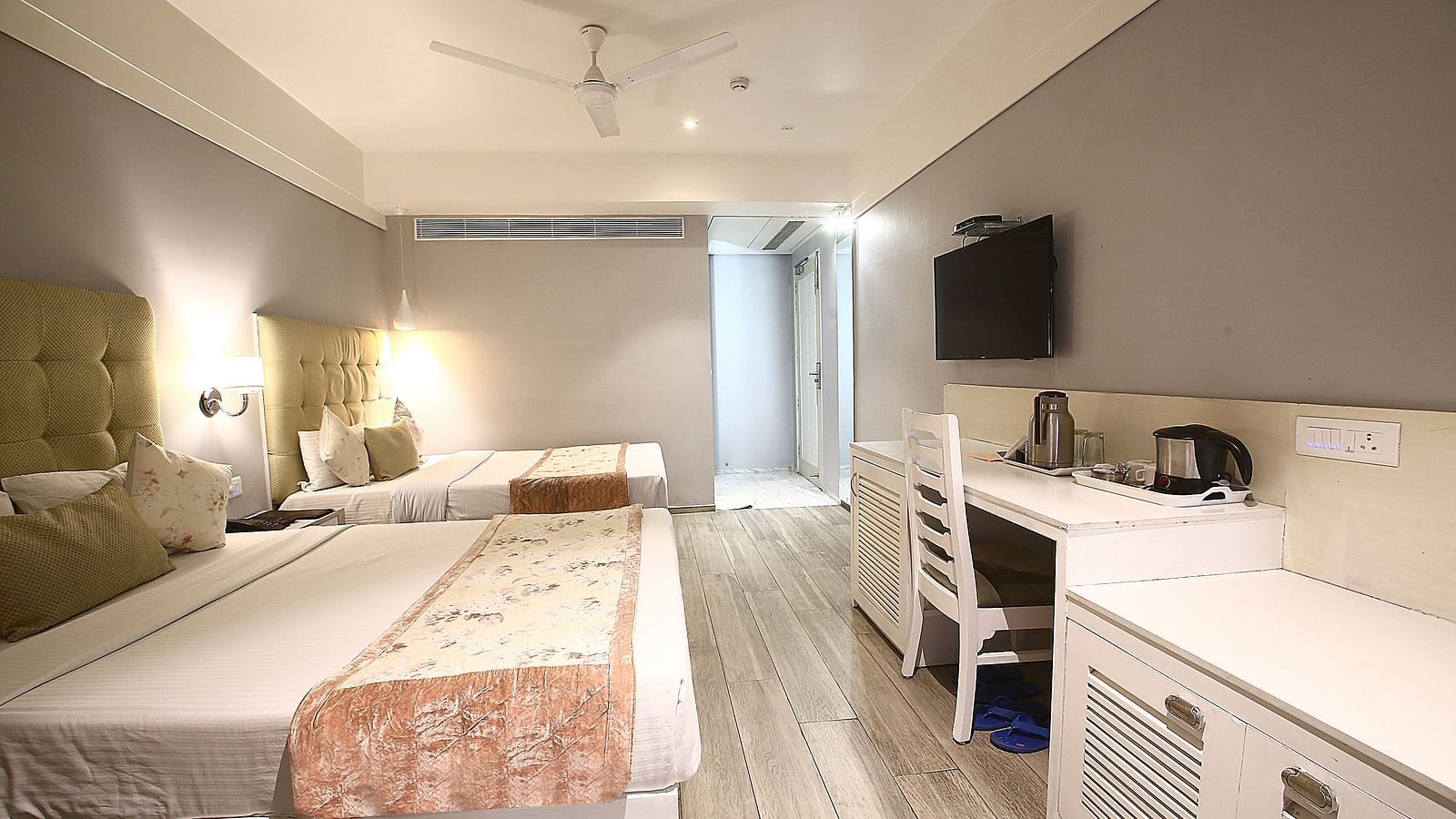 A bright and airy hotel room with twin beds, a white wooden desk, and a relaxing ambience - Hotel Emerald, Chandigarh