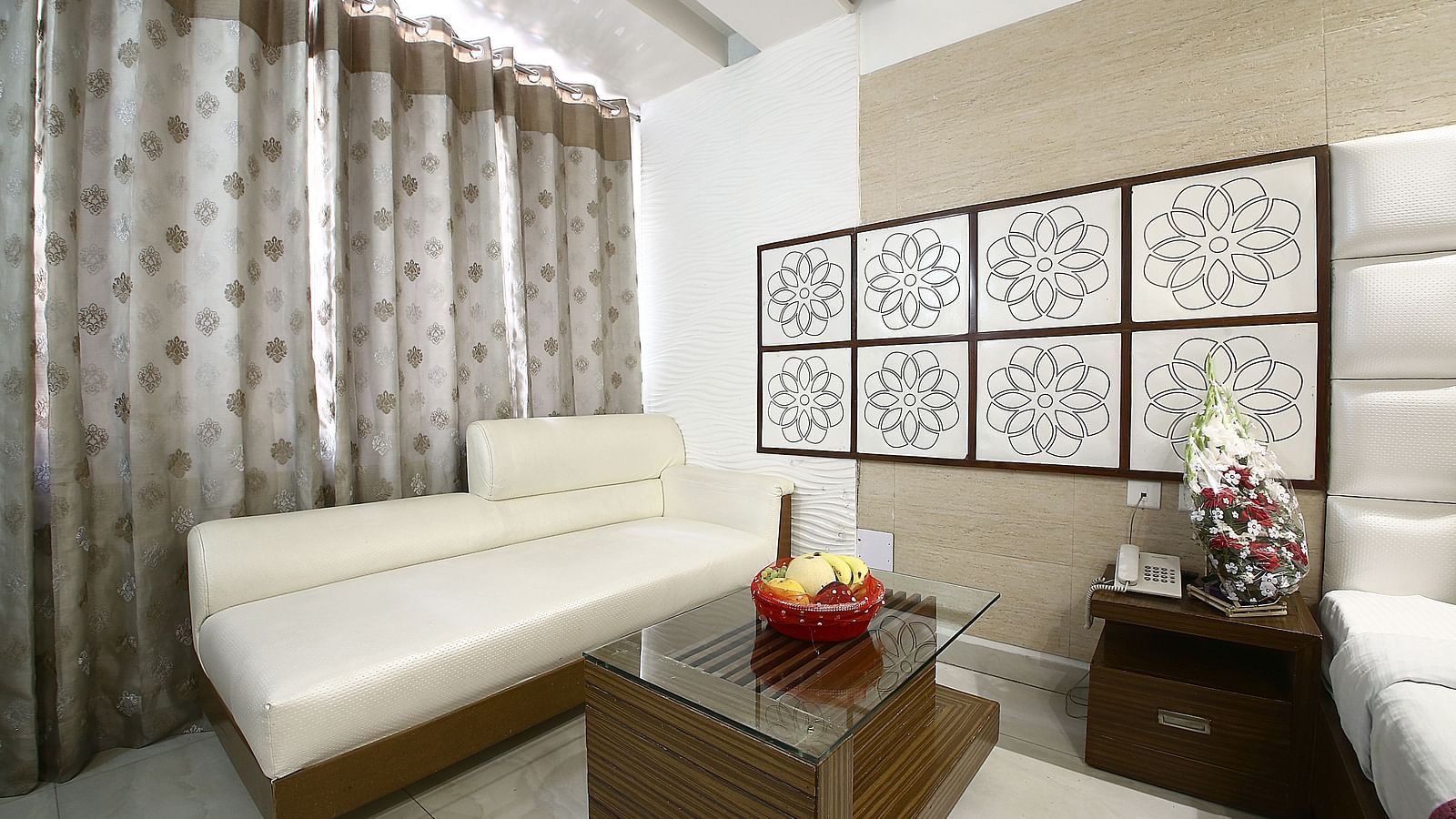 A stylish hotel room with a comfortable sofa, artistic wall decor, and soft ambient lighting.
