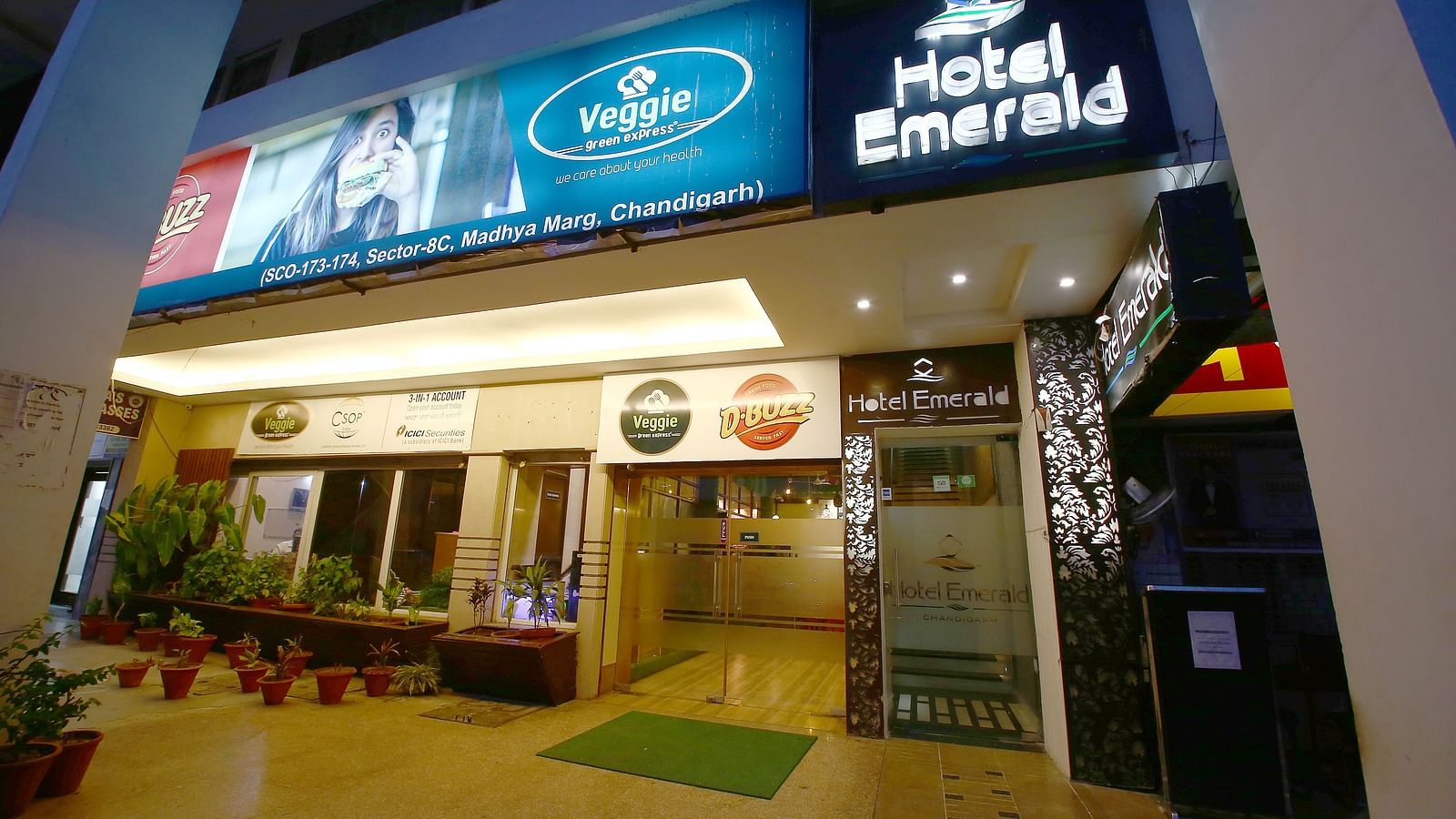 The exterior view of Hotel Emerald at night, with bright signage and an inviting entrance - Hotel Emerald, Chandigarh