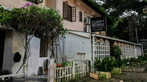 Heritage colonial-style building with trees lining a quiet street.