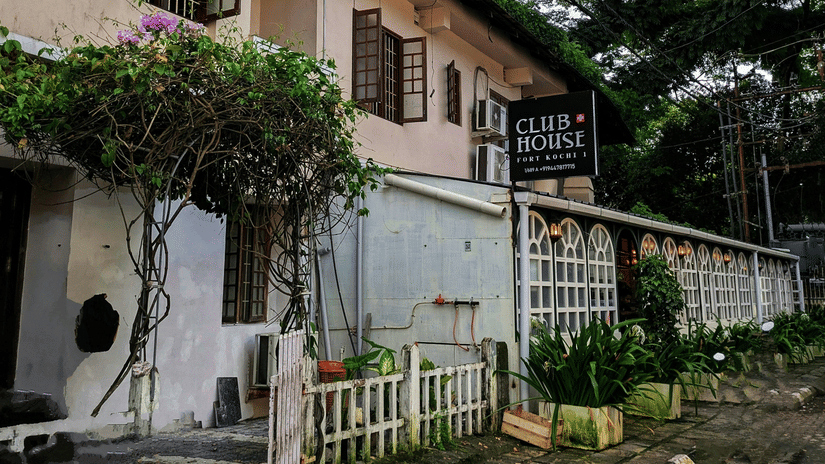 Heritage colonial-style building with trees lining a quiet street.