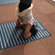 A person striking a yoga pose on a mat by the waters at Hotel Devnadi, Haridwara.