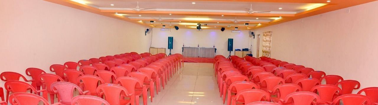 An image of the seating arrangement at the banquet hall  with a table and chairs placed on a podium at Nisarga Lake Resort