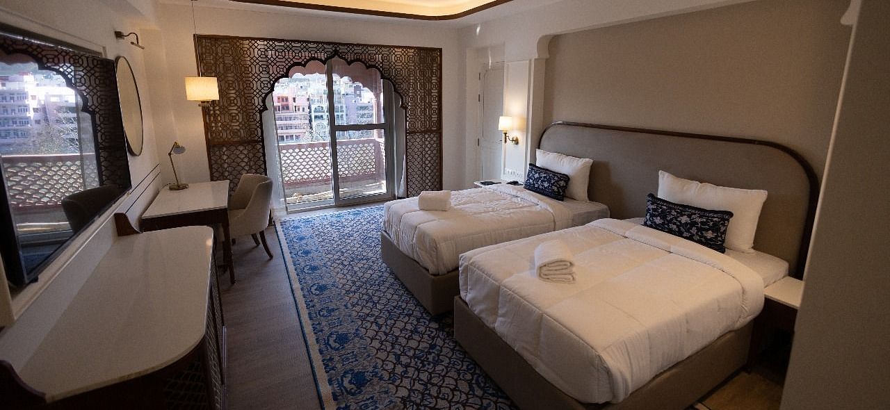 Full view shot of the Jalrupa Room with two comfortable single beds with a false ceiling at Bhagirathi by RDB Atishay.