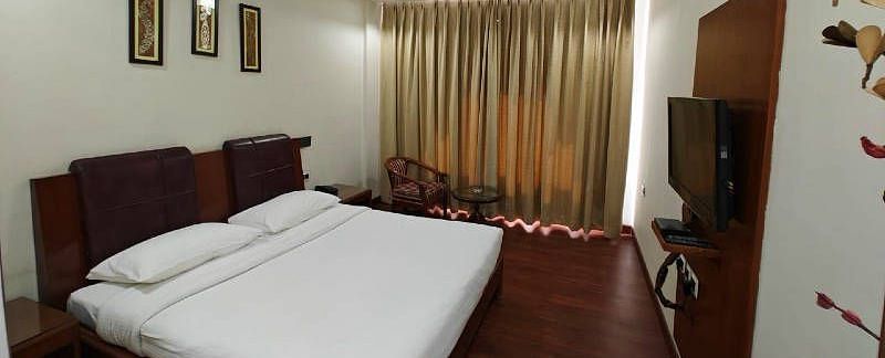Full view shot of the bedroom of the Suite with golden coloured curtains blocking the natural sunlight - Hotel Gold, Panipat