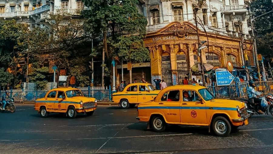 An image of the streets of Kolkata with yellow taxis and a building in the background