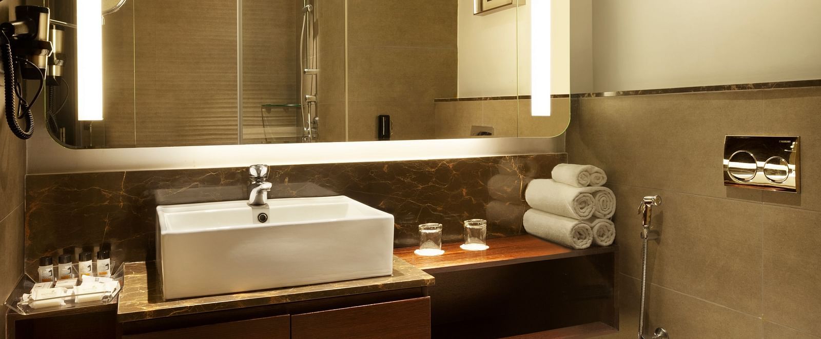 A spacious washroom with a large wall-mounted mirror, a washbasin below it, and a western toilet to the side | Cenneys Gateway