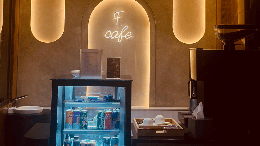 Front view of the F Cafe featuring a mini fridge with transparent door at F Hotels, Bengaluru.