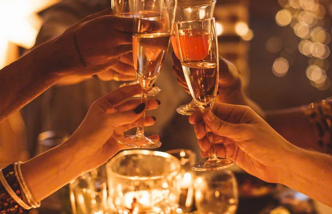  A group of people toasting with champagne glasses at a warmly lit festive gathering