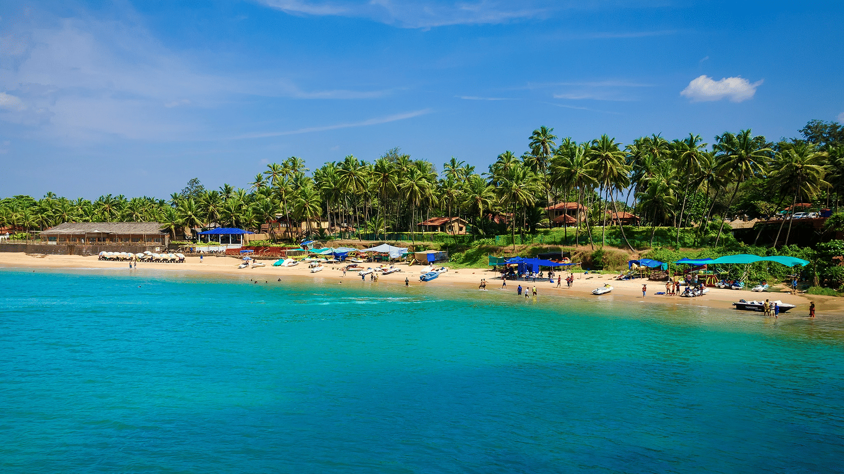 An aerial view of people basking in the sun near the blue water of the Colva Beach. It is one of the best tourist attractions in South Goa.