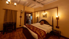 Side view of Heritage Room with a cosy bed and stylish interior lighting at Himalaya Hotel, Nainital