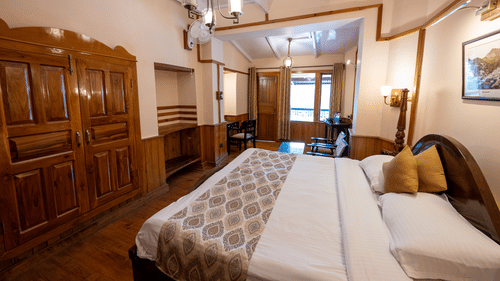 Side view of the Heritage Room with a cozy bed at Himalaya Hotel, Nainital