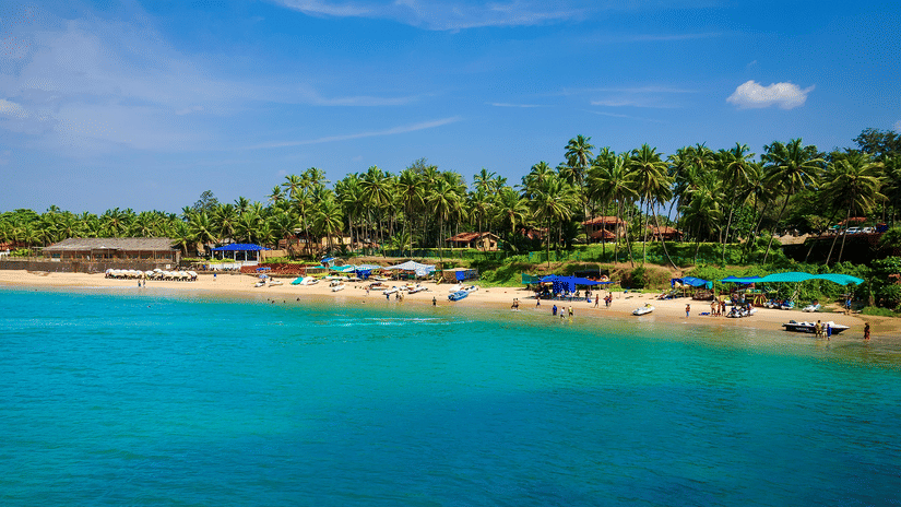 An aerial view of people basking in the sun near the blue water of the Colva Beach. It is one of the best tourist attractions in South Goa.