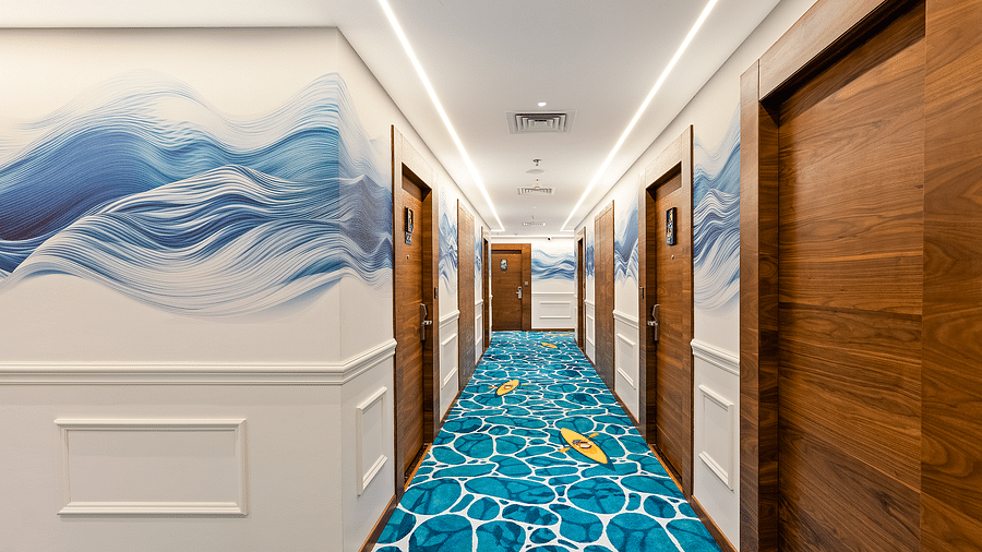 Sea-inspired décor adorns the walls and floor of the corridor at Cloud9 Sarovar Premiere, Palolem Goa, creating a tranquil and inviting atmosphere