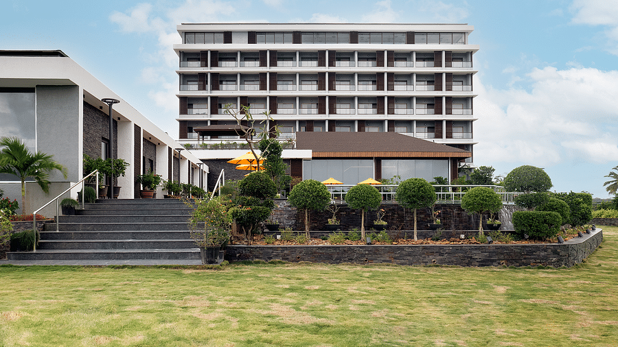 The exterior façade of Cloud9 Sarovar Premiere, Palolem Goa, framed by lush greenery and a cloudy sky, creates a peaceful and inviting atmosphere, making it one of the top hotels near Palolem Beach, South Goa.