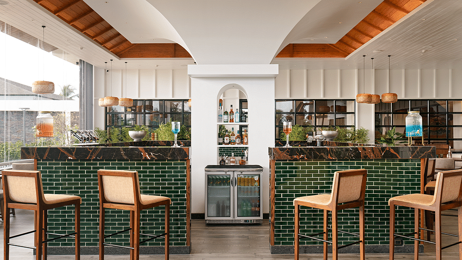  A counter with drinks displayed on it is surrounded by high chairs, offering a comfortable space at Cloud9 Sarovar Premiere, Palolem Goa
