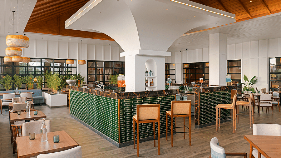 The bar area features bottles neatly arranged on the table and shelves adorned with decorative elements, offering a stylish setting at Cloud9 Sarovar Premiere, Palolem Goa
