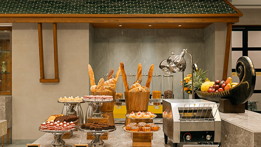 A marble-finished counter displays a variety of pastries, including donuts, cakes, and breads in different shapes and sizes, at Cloud9 Sarovar Premiere, Palolem Goa