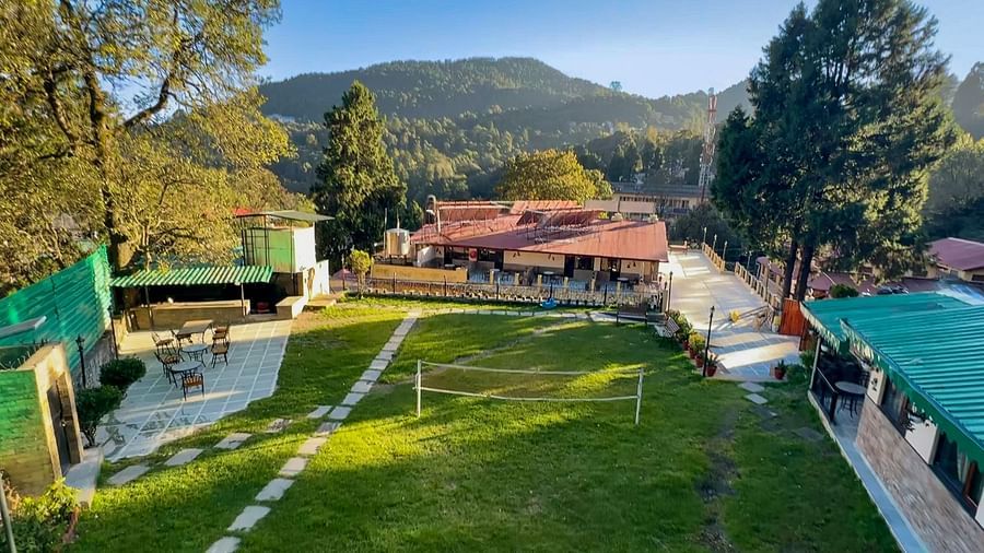 Aerial view of the badminton court with a chair, table, and net at The Pavilion, Nainital