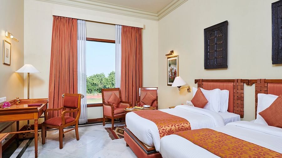 a deluxe room at The Ummed Jodhpur, Palace Resort and Spa with twin bed featuring soft white linens and a window offering great view