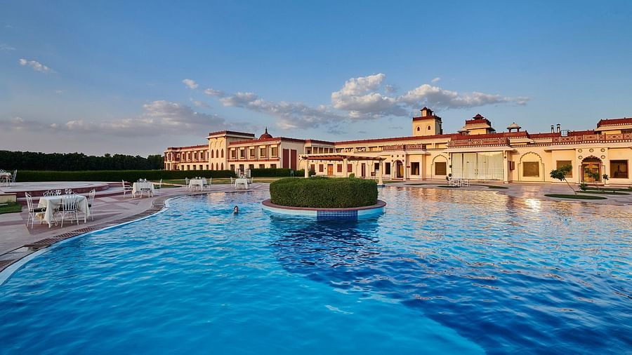day time view of crystal blue waters in a pool with resort in the background - The Ummed Jodhpur, Palace Resort and Spa2