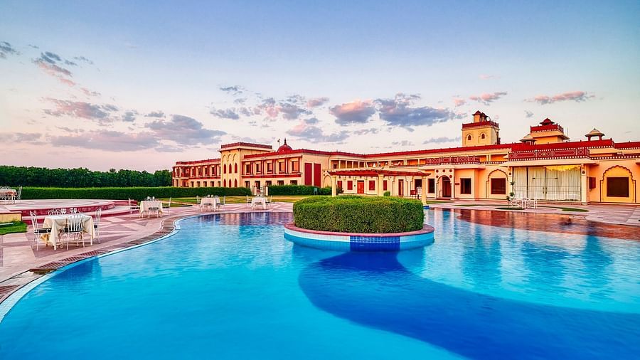 day time view of crystal blue waters in a pool with resort in the background - The Ummed Jodhpur, Palace Resort and Spa3