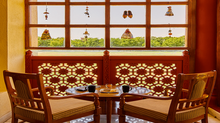 Royal Suite Courtyard with two chairs and a teapoy in front of a beautiful window - The Ummed Jodhpur, Palace Resort and Spa